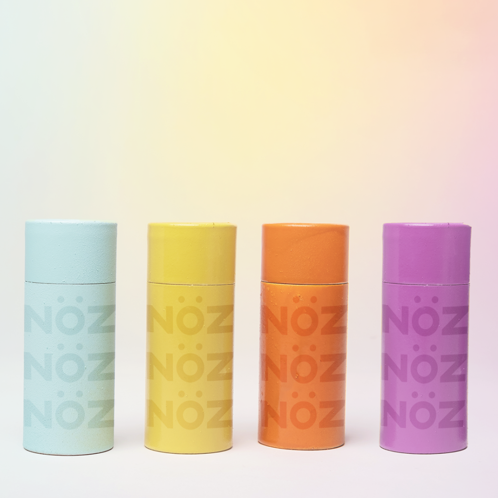 Reef safe Nözscreen in blue, yellow, orange and purple colors on gradient background